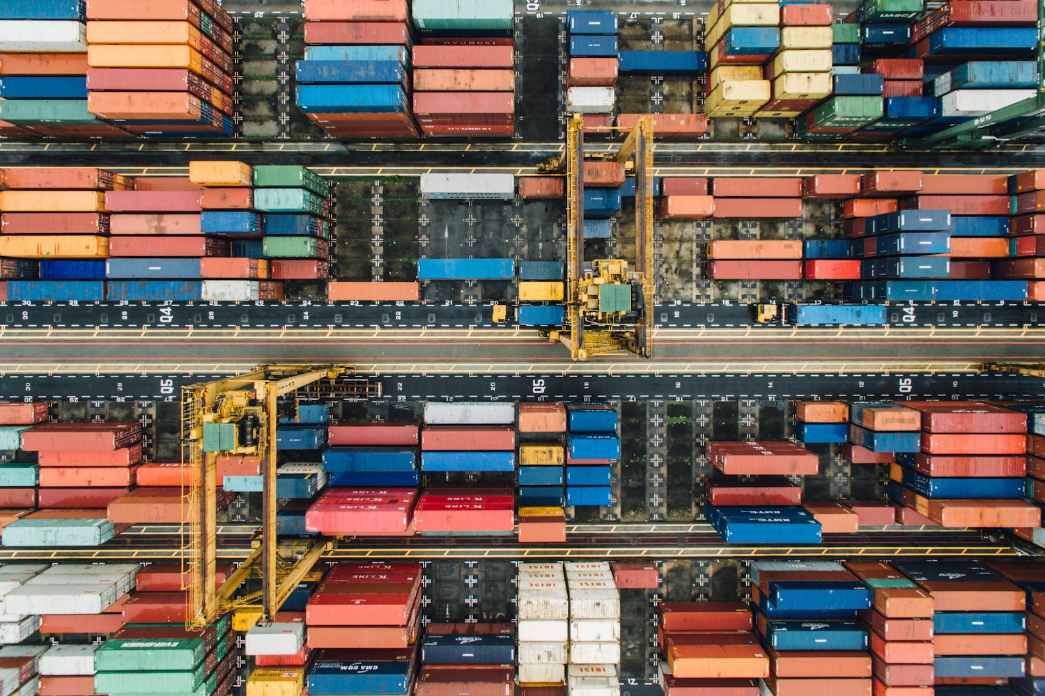 Aerial view of shipping containers and cranes in a port terminal